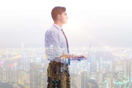 Successful businessman against cityscape in business conceptの写真素材