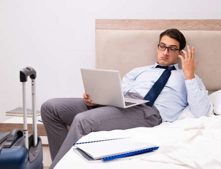 Businessman working during business trip in hotelの写真素材