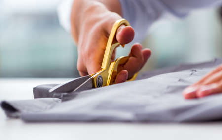 Young man tailor working on new clothingの写真素材