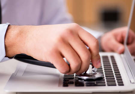 IT technician repairing broken laptop notebook computer
