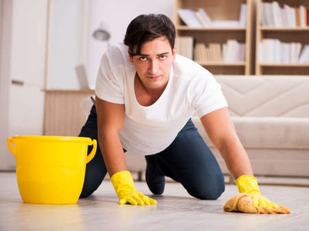 Man husband cleaning the house helping wifeの写真素材