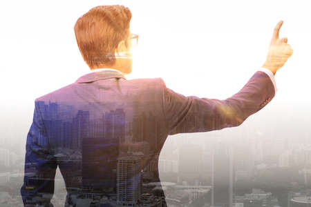 Successful businessman against cityscape in business conceptの写真素材