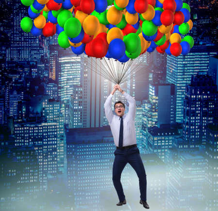 Businessman flying on balloons in challenge conceptの写真素材