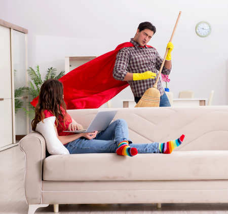 Superhero husband helping his wife at homeの写真素材