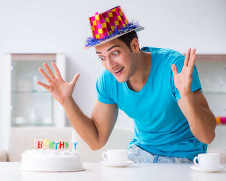 Young man celebrating birthday alone at homeの写真素材
