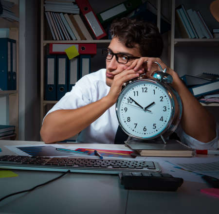 Man businessman working late hours in the officeの写真素材