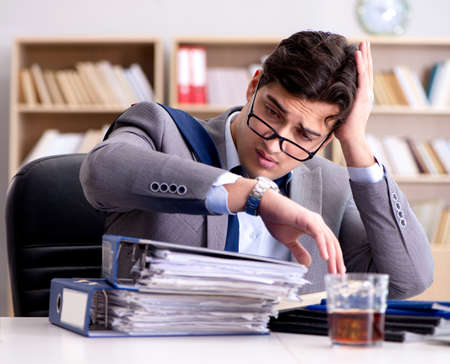 Young businessman drinking from stressの写真素材