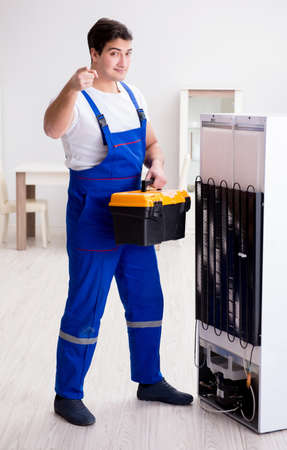 Repairman contractor repairing fridge in DIY conceptの写真素材