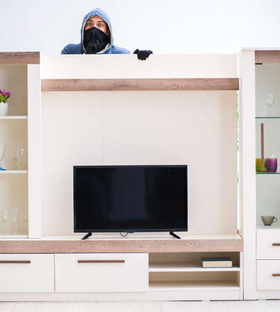 The man burglar stealing tv set from houseの写真素材