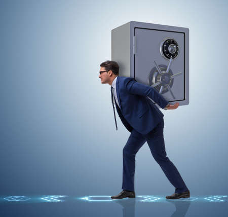 BUsinessman stealing metal safe from bankの写真素材