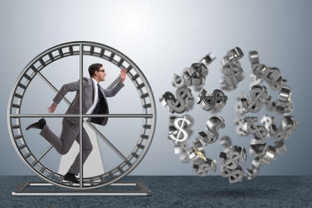 Business concept with businessman running on hamster wheelの写真素材