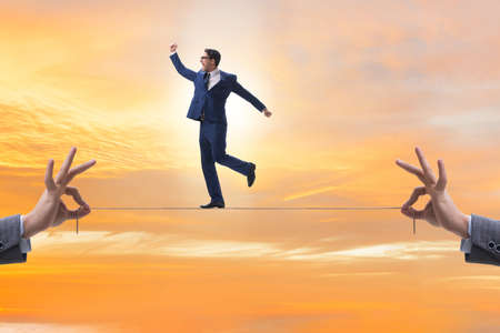 The businessman walking on tight rope