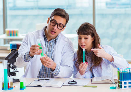 Two chemists working in lab experimentingの写真素材