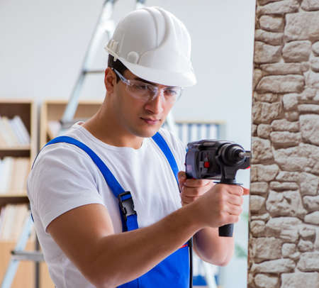 Repairman working with drilling drill perforator