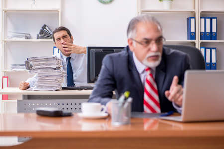 Old boss and young male employee in the officeの写真素材