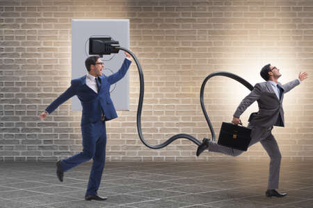Businessman being powered by electricity and plug