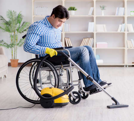 Disabled man cleaning home with vacuum cleanerの写真素材
