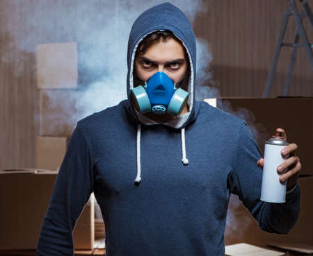 Graffiti painter in dark smokey room