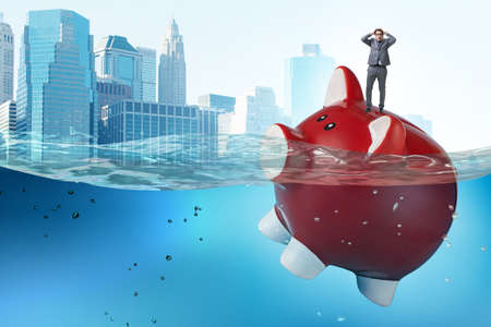 The businessman in debt concept with piggybank