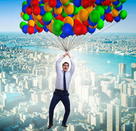Businessman flying on balloons in challenge concept