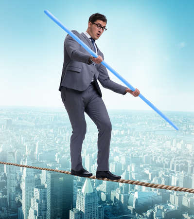 Businessman doing tightrope walking in risk conceptの写真素材