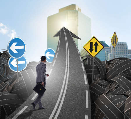 Businessman in uncertainty concept on road intersection crossroaの写真素材