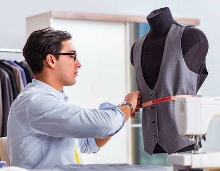 Young man tailor working on new clothing