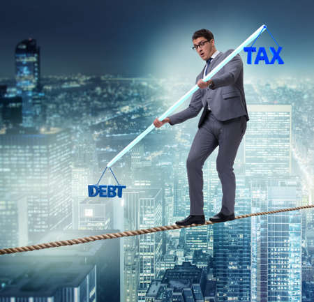 Businessman balancing between debt and taxの写真素材