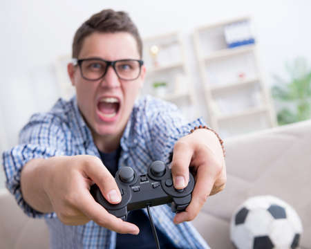 Young man playing computer games at home