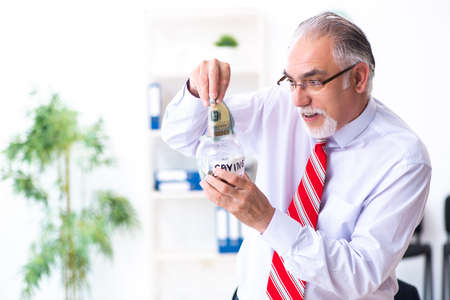 Old male accountant in budget planning conceptの写真素材