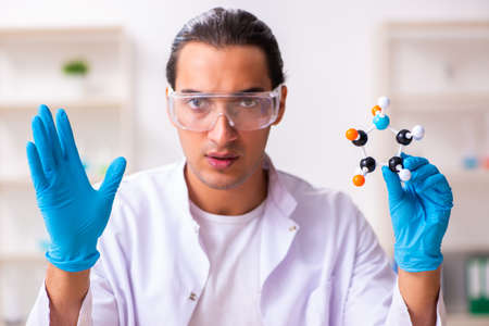 Young male nutrition expert testing food products in labの写真素材