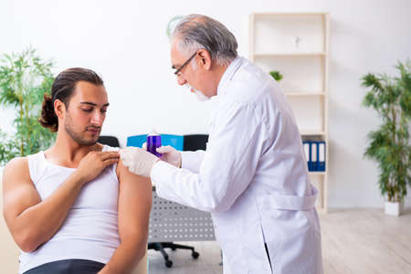 Young male patient visiting experienced doctorの写真素材