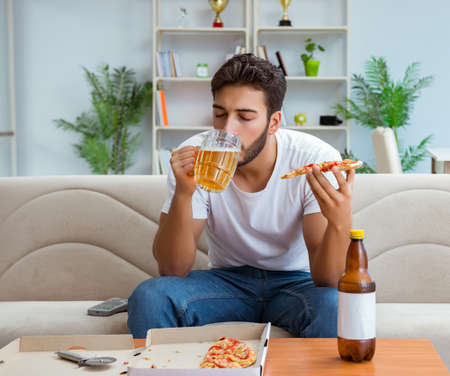 Man eating pizza having a takeaway at home relaxing restingの写真素材