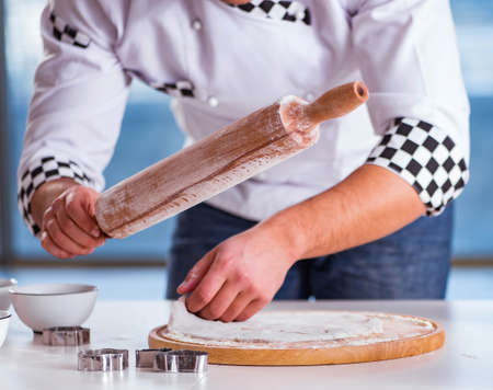 The young man cooking cookies in kitchen