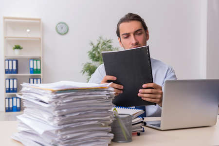 Young male businessman employee unhappy with excessive work