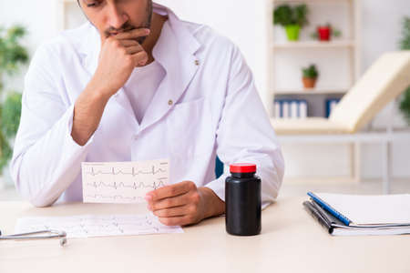 Old man visiting young doctor cardiologistの写真素材