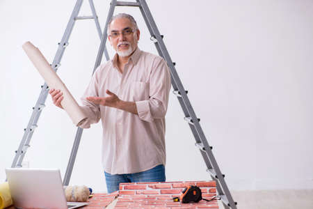 Old husband contractor in home renovation conceptの写真素材