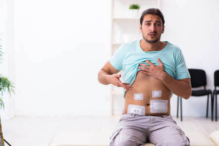 Injured young man visiting experienced male doctor