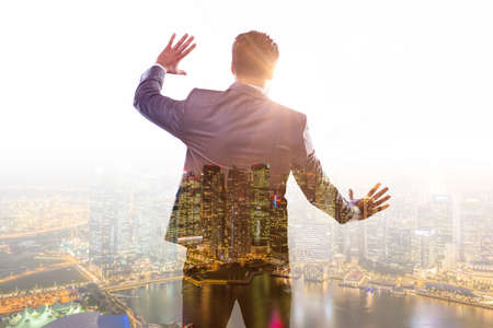 Successful businessman against cityscape in business conceptの写真素材