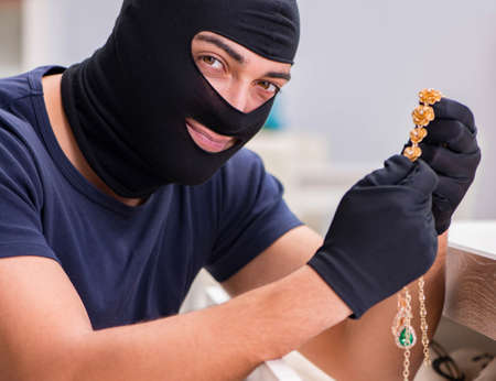 Robber wearing balaclava stealing valuable thingsの写真素材
