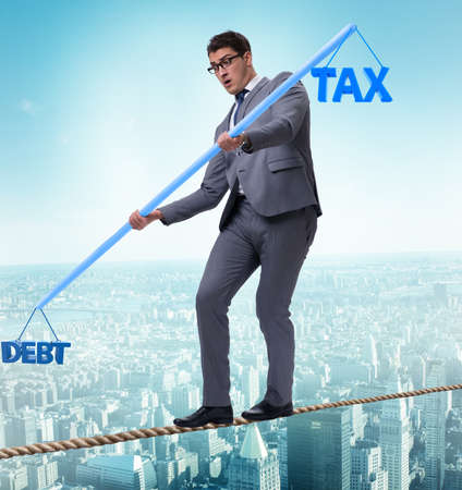 Businessman balancing between debt and taxの写真素材