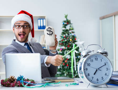Young businessman celebrating christmas in the officeの写真素材