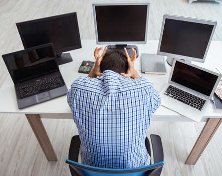 The businessman sitting in front of many screensの写真素材