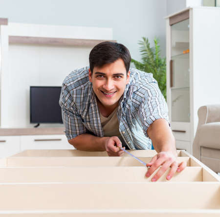 Man assembling furniture at homeの写真素材