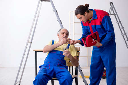 Two contractors in first aid conceptの写真素材