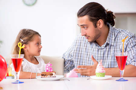 Father celebrating birthday with his daughterの写真素材