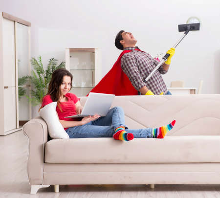 Superhero husband helping his wife at homeの写真素材