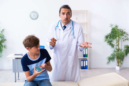 Young male doctor examining boy in the clinicの写真素材