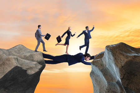 Businessman acting as a bridge in support conceptの写真素材