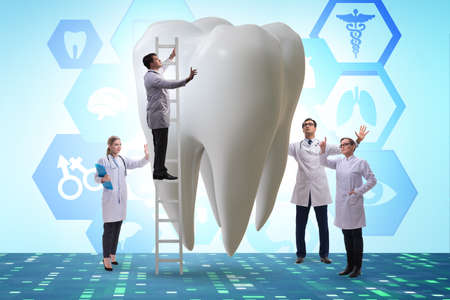 Doctors examining giant tooth in dental conceptの写真素材